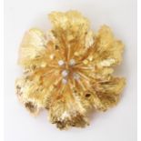 AN 18CT GOLD RETRO BROOCH in the shape of a flower with diamond set stamens, diameter approx 4cm,