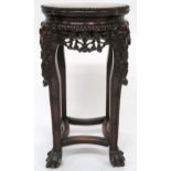 A CHINESE HARDWOOD JARDINERE STAND  with shaped top inset with pink marble over floral carved