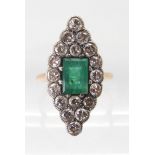 AN EMERALD AND DIAMOND RING mounted in yellow and white metal, the step cut emerald with the