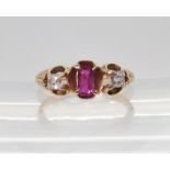 A VINTAGE THREE STONE RING set with two old cut diamonds and a mixed cut ruby in a scroll engraved