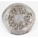 A BURMESE WHITE METAL TRAY of circular form, the centre with repousse decoration of deities and
