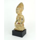 A MAYOMBE MOTHER AND BABY FIGURE, WEST CENTRAL AFRICA Carved from a pale softwood, sat upon a