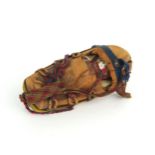 A PAPOOSE DOLL, NORTH AMERICA Formed of a buckskin outer covering with tacked wool felt banding, the