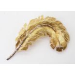 AN 18CT GOLD FEATHER BROOCH made from both yellow and white gold with engraved detail. Length 6cm