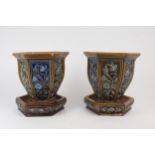 A PAIR OF UNMARKED DOULTON STONEWARE JARDINIERES AND SAUCERS each of hexagonal form with panels of
