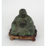 A CHINESE BRONZE MODEL OF HOTEI Seated and holding his sack, with wood stand, 12cm high Condition
