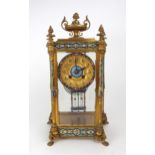 A FRENCH CHAMPLEVE ENAMEL AND GILT BRASS MANTEL CLOCK with four glass panels revealing the movement,