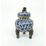 A CLOISONNE AND GILT METAL CENSER Decorated with blue and white flower heads and on three mask legs,