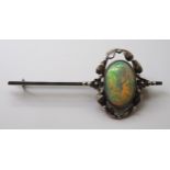 AN ARTS & CRAFTS OPAL BROOCH set with a 16mm x 11.5mm solid opal with exceptional orange, red, green