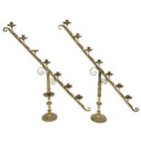 A PAIR OF 19TH CENTURY BRASS ECCLESIASTICAL SLOPED CANDELABRA each with seven candle holders with
