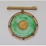 A CHINESE GREEN HARDSTONE RONDEL BROOCH the centre with Chinese symbol, in a twisted wirework 9ct