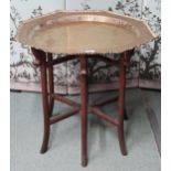 A 20th century Oriental octagonal brass topped table on folding base, 67cm high x 71cm wide x 70cm