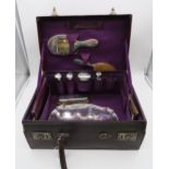 A matched cased travelling vanity set, comprising a three piece silver dressing set, four silver