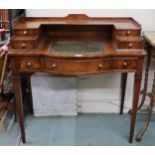 A 20th century reproduction mahogany writing desk with four drawered superstructure over central