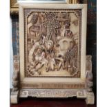 An early 20th century Chinese table screen carved with village scene on carved supports joined by