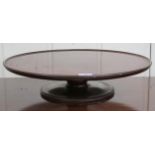 A 19th century mahogany "lazy Susan" dumbwaiter, circular top with raised edges on turned column