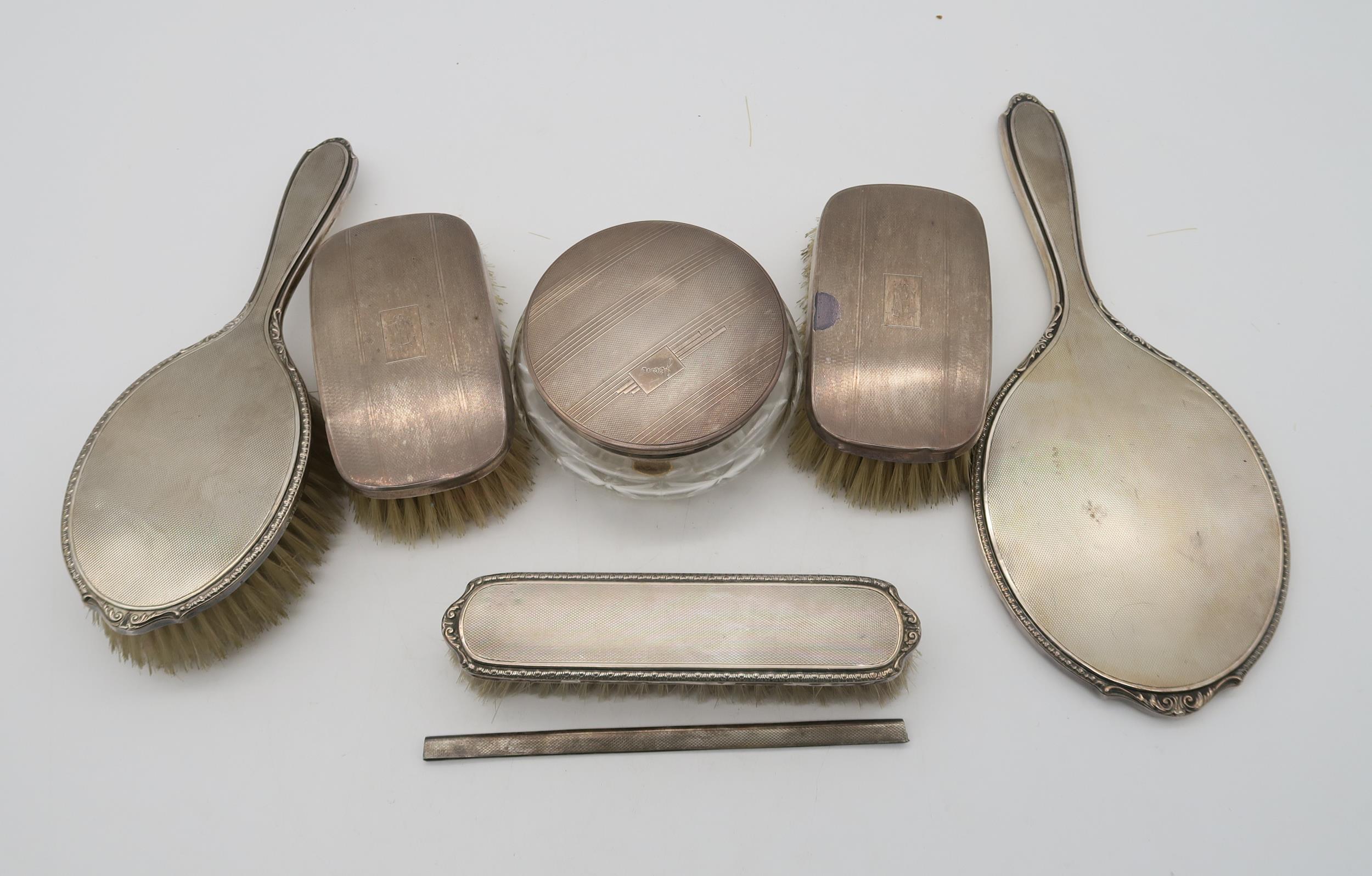 A collection of silver dressing table set items, a three piece set by Adie Brothers Ltd, Birmingham,