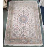 A cream floral patterned ground Tabriz rug with light blue central medallion, matching spandrels and