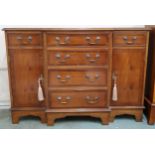 A 20th century reproduction mahogany breakfront sideboard with four central drawers flanked by