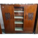 A 20th century Oriental hardwood bookcase with central glazed door flanked by cabinet doors on