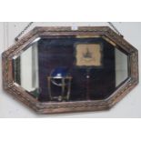 An early 20th century hammered copper framed bevelled glass wall mirror, 50cm high x 84cm wide