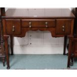A Victorian mahogany desk with central drawer flanked by short drawers joined by shaped apron on