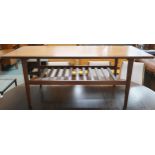 A mid 20th century teak coffee table with rectangular top on square tapering supports joined by