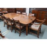 A Victorian wind out extending dining table and eight sabre legged dining chairs, table with two
