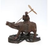 A Chinese carved figure of a boy carrying a horn parasol  riding a water buffalo, on a