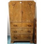 An early 20th century Art Deco burr walnut veneered gents robe with pair of cabinet doors over three