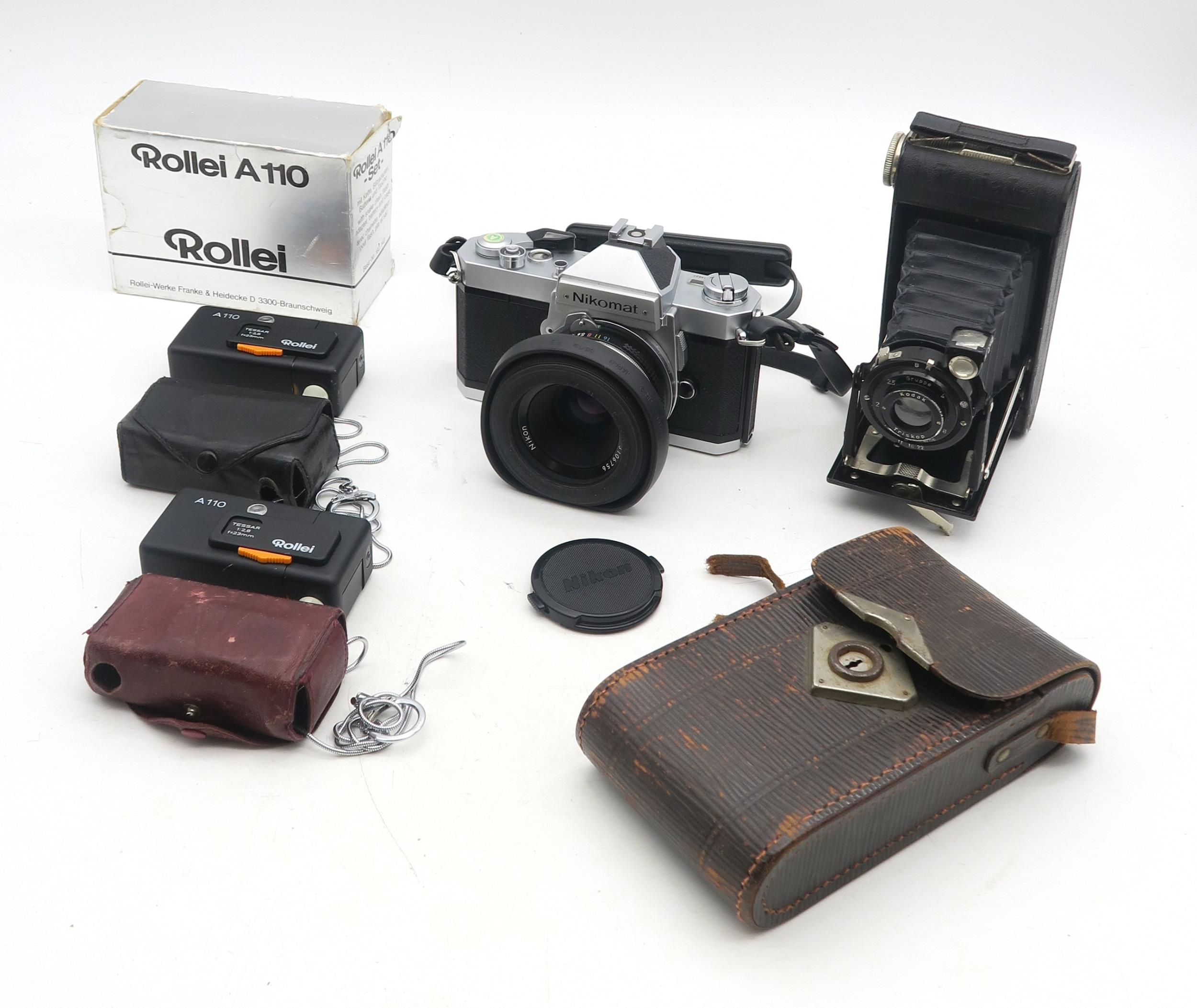 A Japanese Nikomat film camera, fitted with a Nikon Nikkor 50mm 1:2 lens, two Rollei A110 sub-