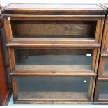 An early 20th century Globe Wernicke three tier sectional bookcase with glazed fall front doors (one