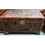 A 20th century Chinese camphorwood blanket chest with extensive carvings on shaped feet, 57cm high x