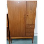 A mid 20th century teak Uniflex gents wardrobe with larger door alongside smaller door over three