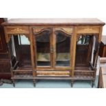 A Victorian rosewood display cabinet with pair of glazed doors flanked by open galleried shelves