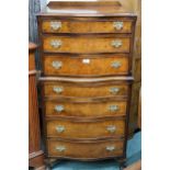 A 20th century mahogany and walnut veneered serpentine front chest on chest with three drawers