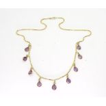 An Arabic gold necklace stamped with the seagull mark, and set with pear shaped purple gems,