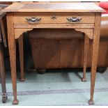 A late Victorian Arts & Crafts style oak writing desk with brown writing skiver which slides to
