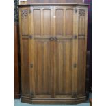 A 20th century oak AY Crown Furniture linen fold pattern two door wardrobe on plinth base, 183cm