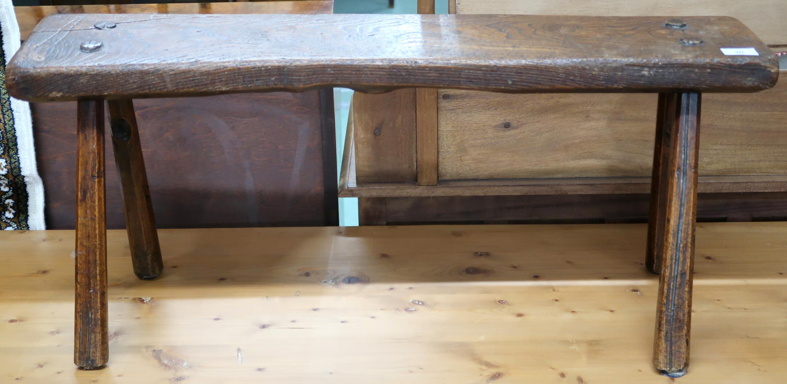 A 19th century elm bench stool with plank seat on chamfered splayed supports, 40cm high x 88cm