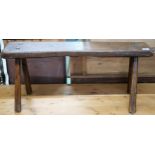 A 19th century elm bench stool with plank seat on chamfered splayed supports, 40cm high x 88cm
