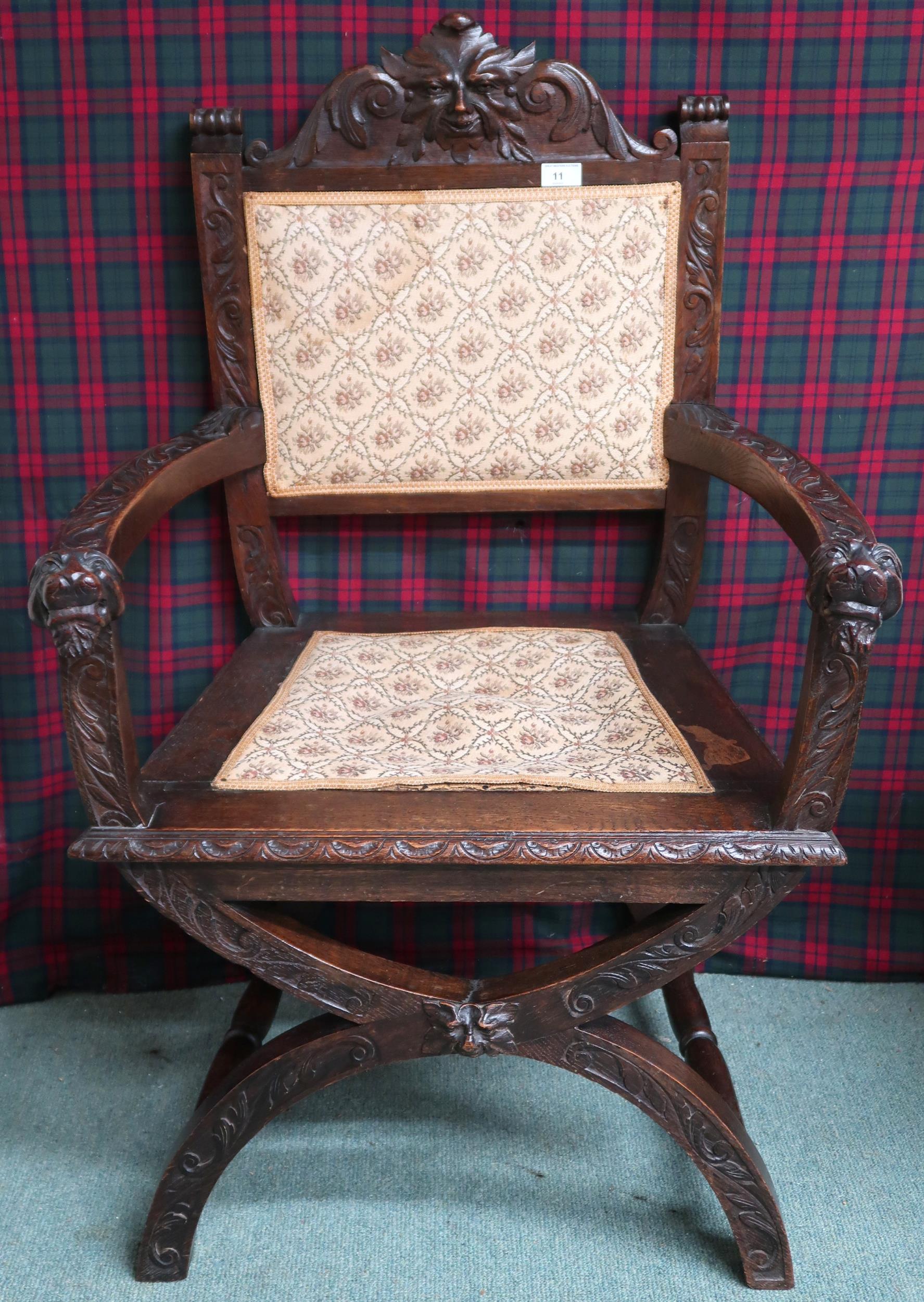 A Victorian oak Gothic revival hall armchair with upholstered splat carved with green man masque