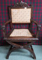 A Victorian oak Gothic revival hall armchair with upholstered splat carved with green man masque