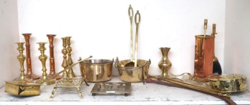 A mixed lot of assorted brass wares to include candlesticks, nut warmers, trivets, fire tools etc