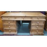 A 20th century pine pedestal desk with rectangular top over single central drawer flanked by four