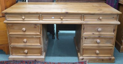 A 20th century pine pedestal desk with rectangular top over single central drawer flanked by four