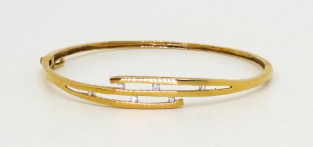 A 9ct gold diamond set bangle, set with estimated approx 0.07cts of brilliant cut diamonds in a