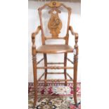 A Victorian walnut framed bergere children's high chair with shaped splat inlaid with game bird over