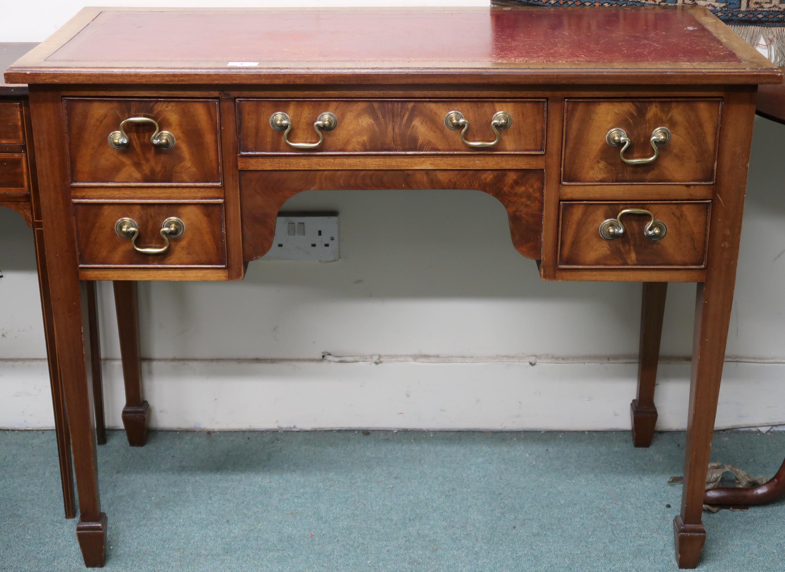 A 19th century mahogany low boy style desk with red skiver over central drawer flanked by two