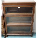 A 20th century oak Gunn three tier sectional bookcase with each section with glazed lift door, 117cm